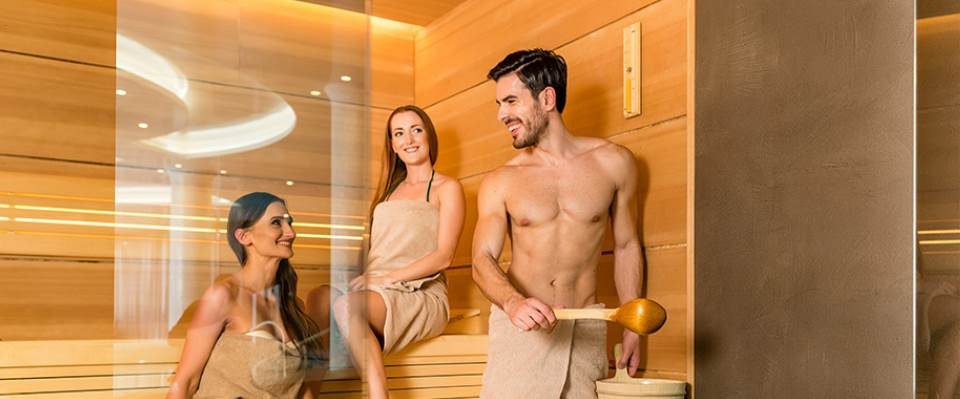 Man and woman sitting calmly in a co-ed sauna room