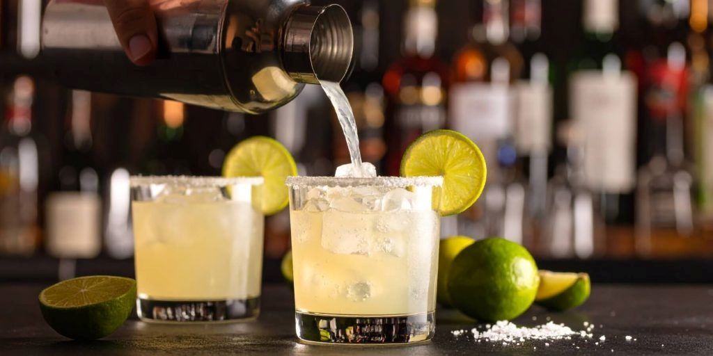 Close-up of tequila bottles and margarita ingredients, highlighting tips for choosing the best tequila for cocktails