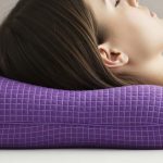 Purple Harmony Anywhere pillow showing signature purple grid cradling a head in side sleeping position