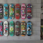YYST W-Style skateboard wall hanger holding a complete deck vertically on a bedroom wall