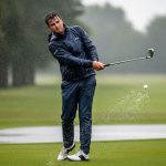 Golfer wearing waterproof jacket playing in heavy rain