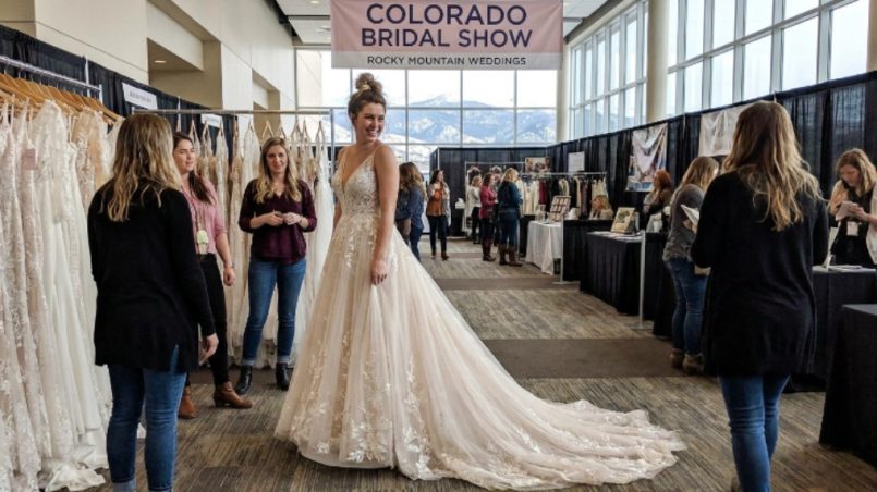 Bride trying on wedding gown at Colorado Bridal Show
