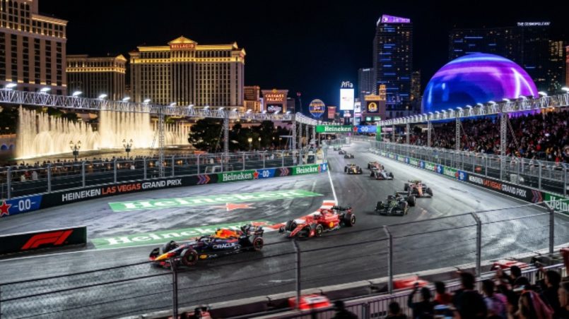 Formula 1 cars racing past Las Vegas Strip hotels at night during the Heineken Las Vegas Grand Prix